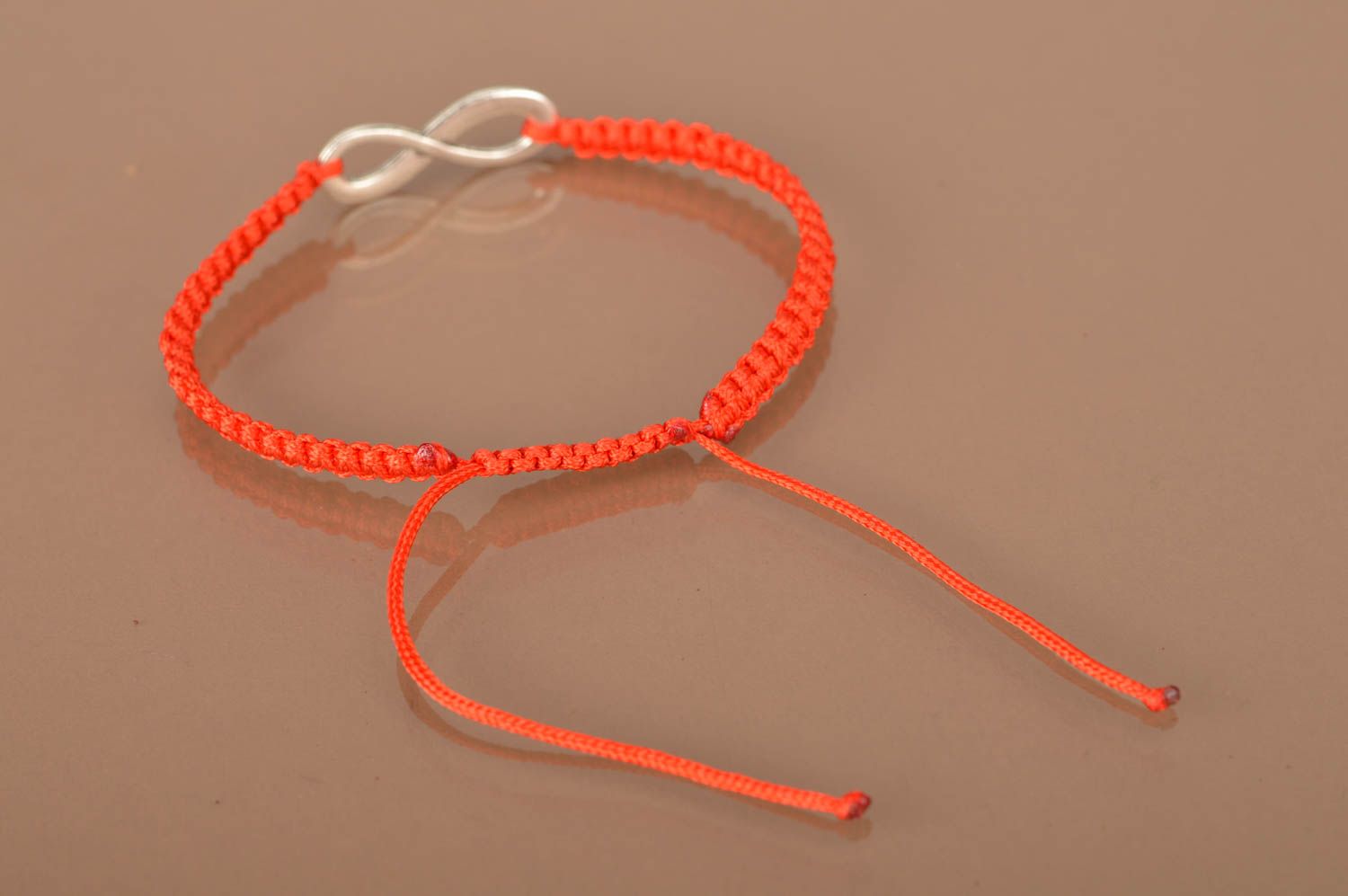 Bracelet tressé rouge en lacet ciré et symbole de l'infini en métal fait main  photo 5