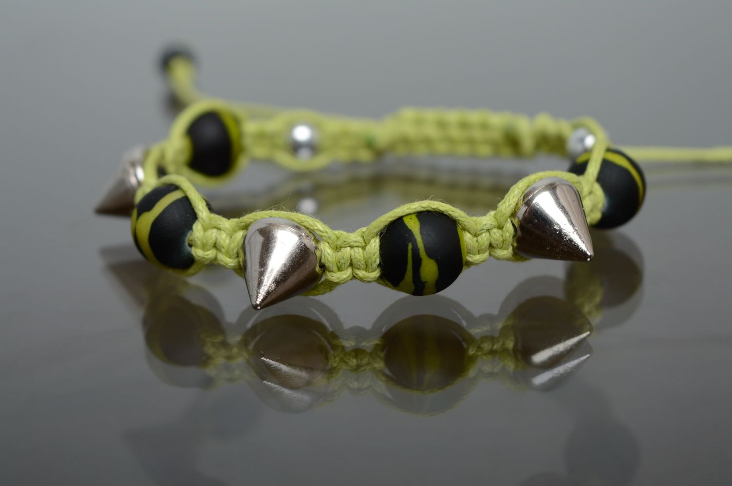Плетеный браслет макраме из вощеного шнурка и металлических шипов фото 1