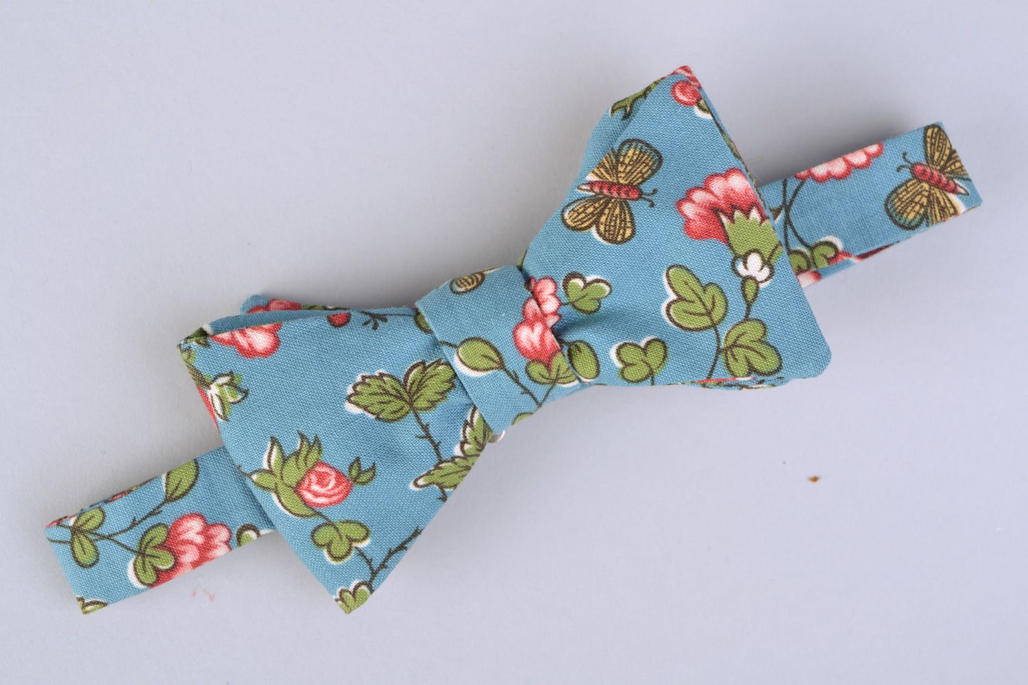 Handmade bow tie sewn of American cotton with flower pattern on blue background photo 3