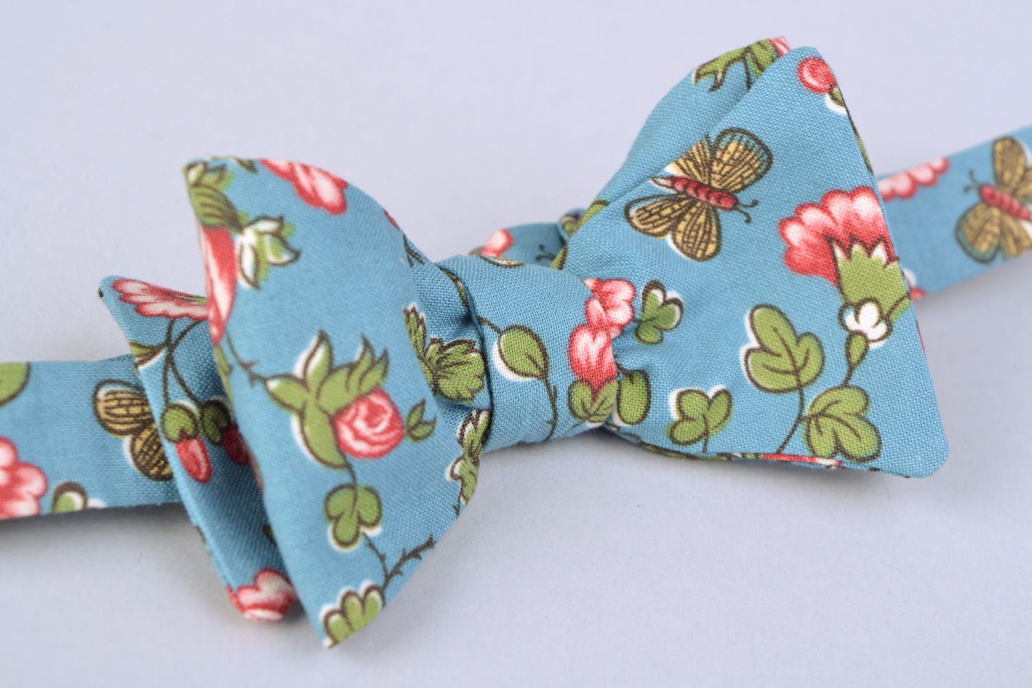 Handmade bow tie sewn of American cotton with flower pattern on blue background photo 5