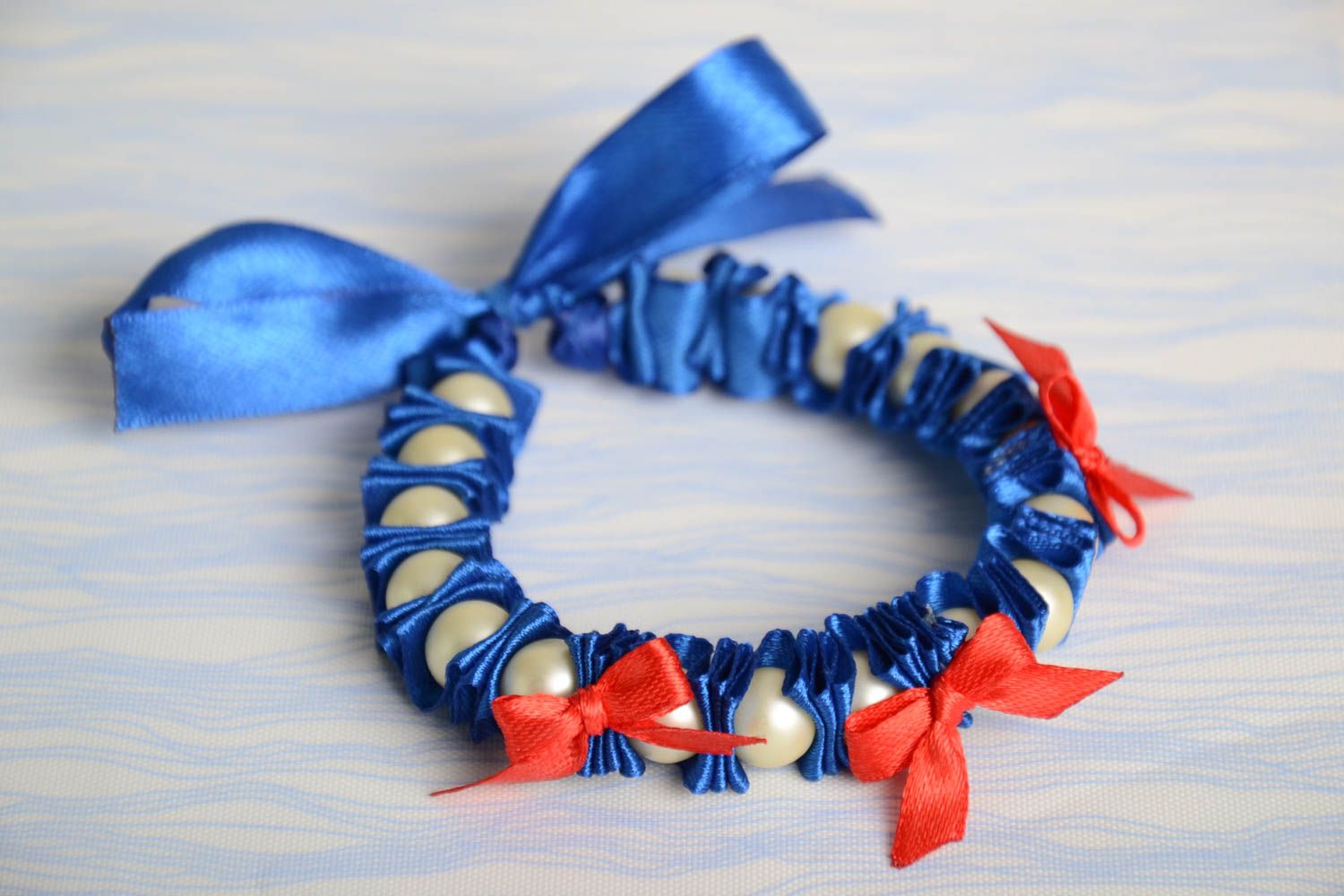 Bracelet fait main de ruban de satin et perles fantaisie bleu avec nœuds rouges photo 1