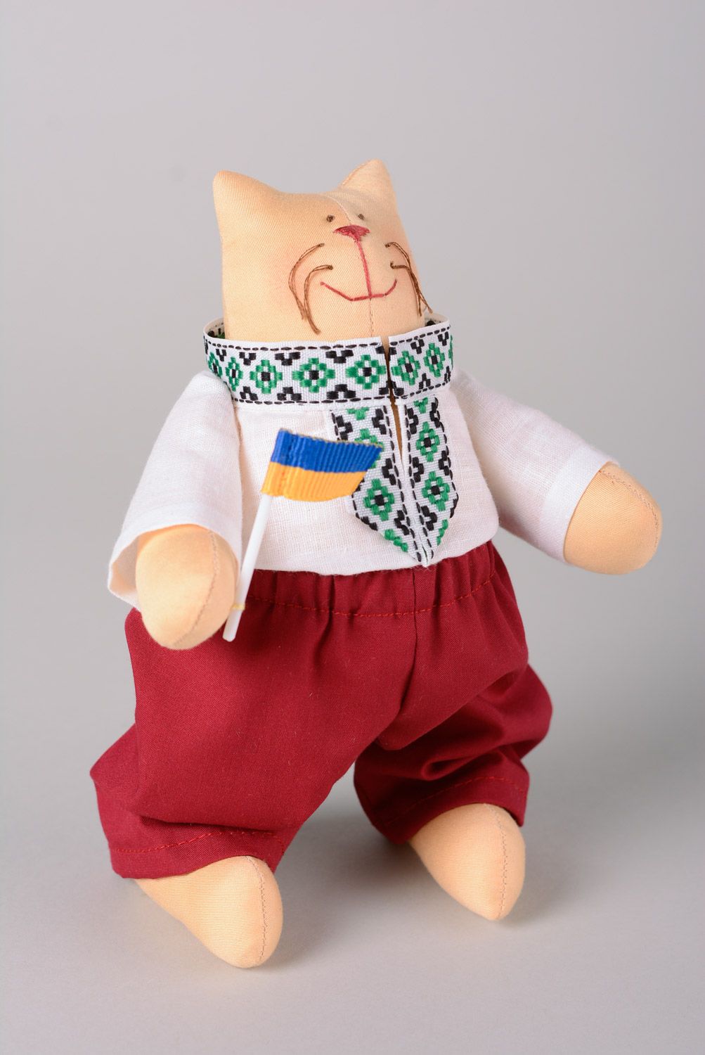 Handmade designer soft toy sewn of cotton in a shape of cat in Ukrainian clothes photo 1