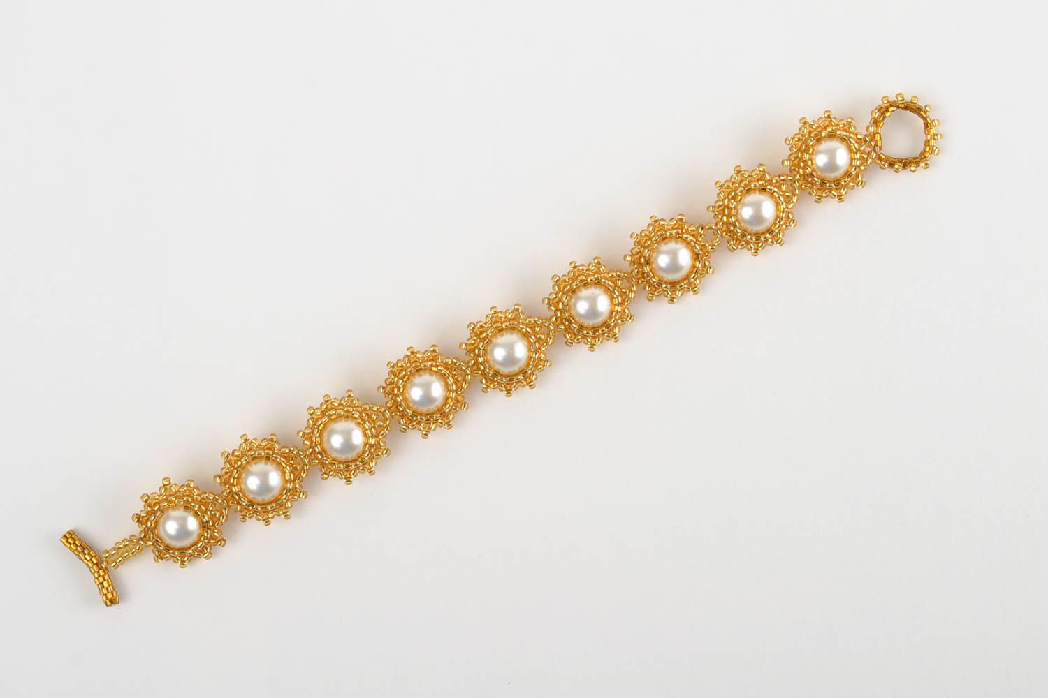Beaded bracelet in the shape of flowers in gold and white colors photo 2