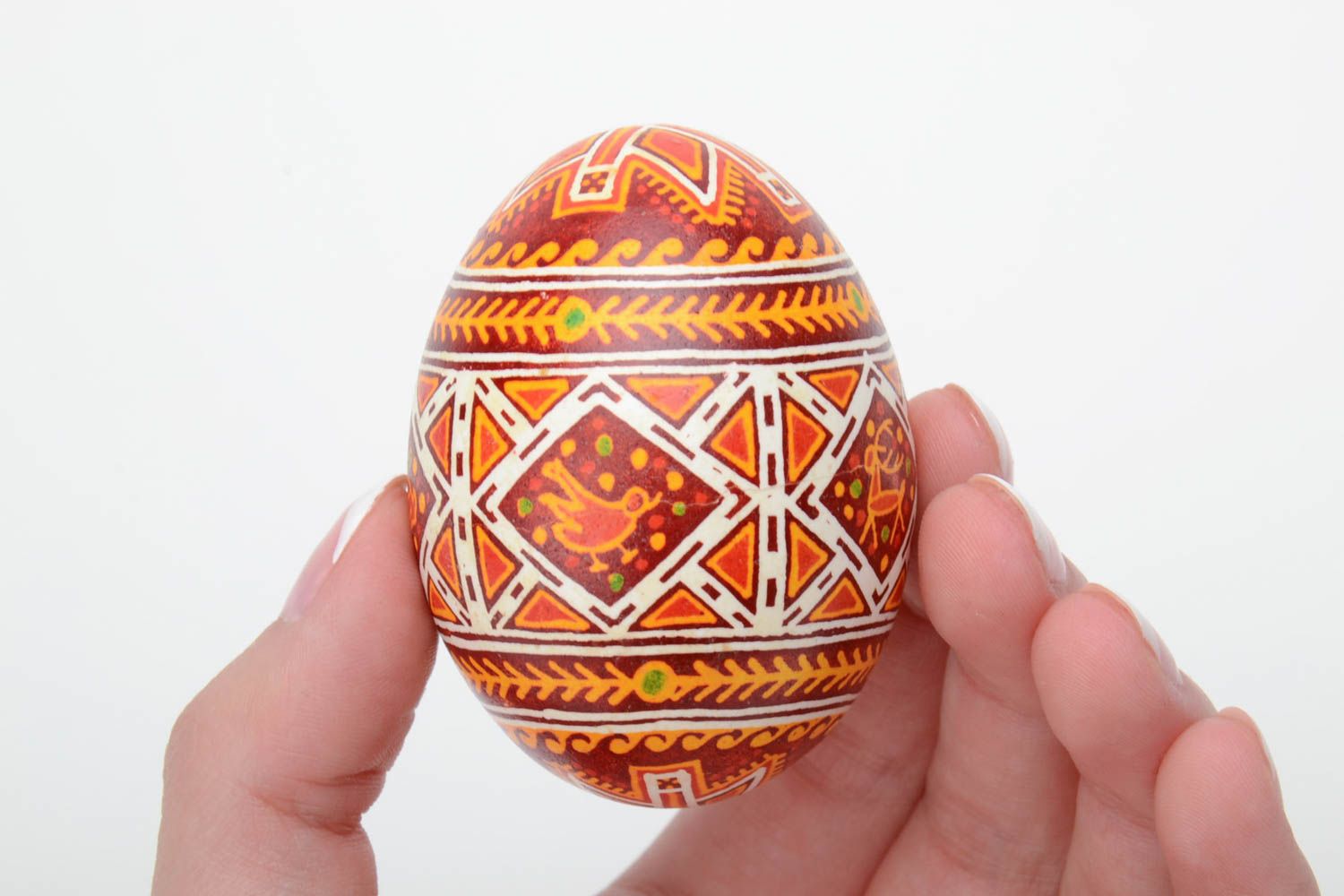 Handmade decorative yellow and red Easter egg painted with wax with deer image photo 5