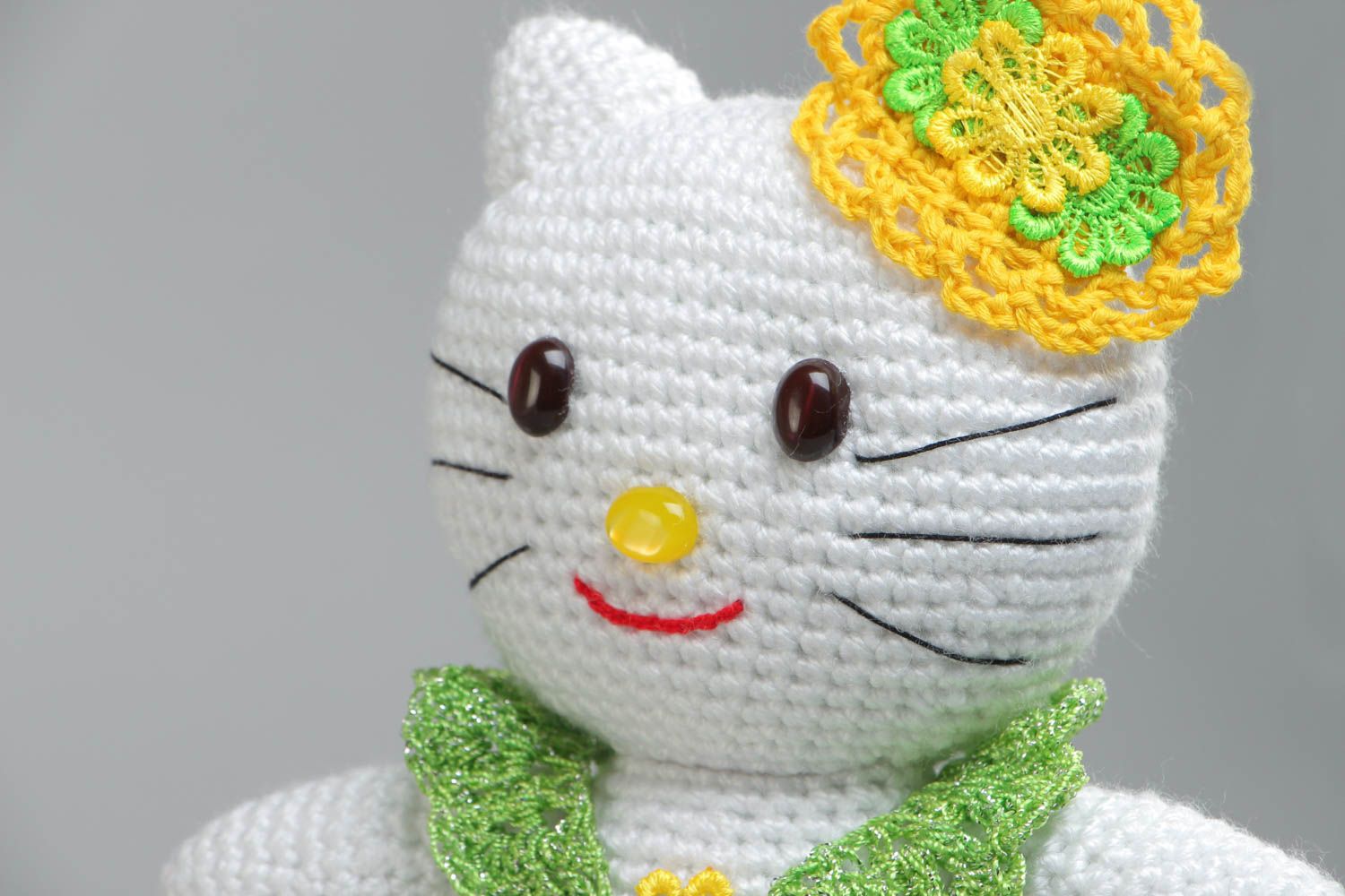 Soft handmade decorative crocheted toy cat in a green dress made of acrylic threads photo 3