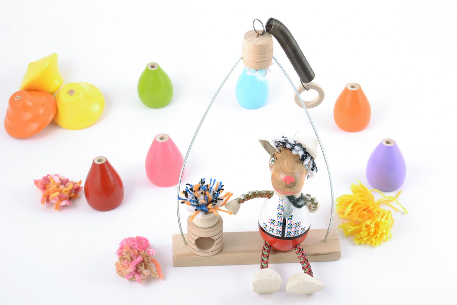 Children's handmade painted wooden toy goat on swing with spring photo 1
