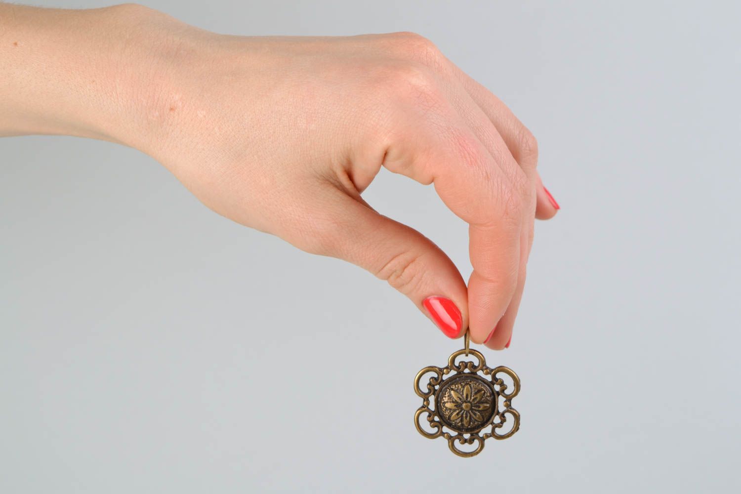 Petit pendentif en métal rond de couleur cuivrée avec fleur unisexe  photo 2