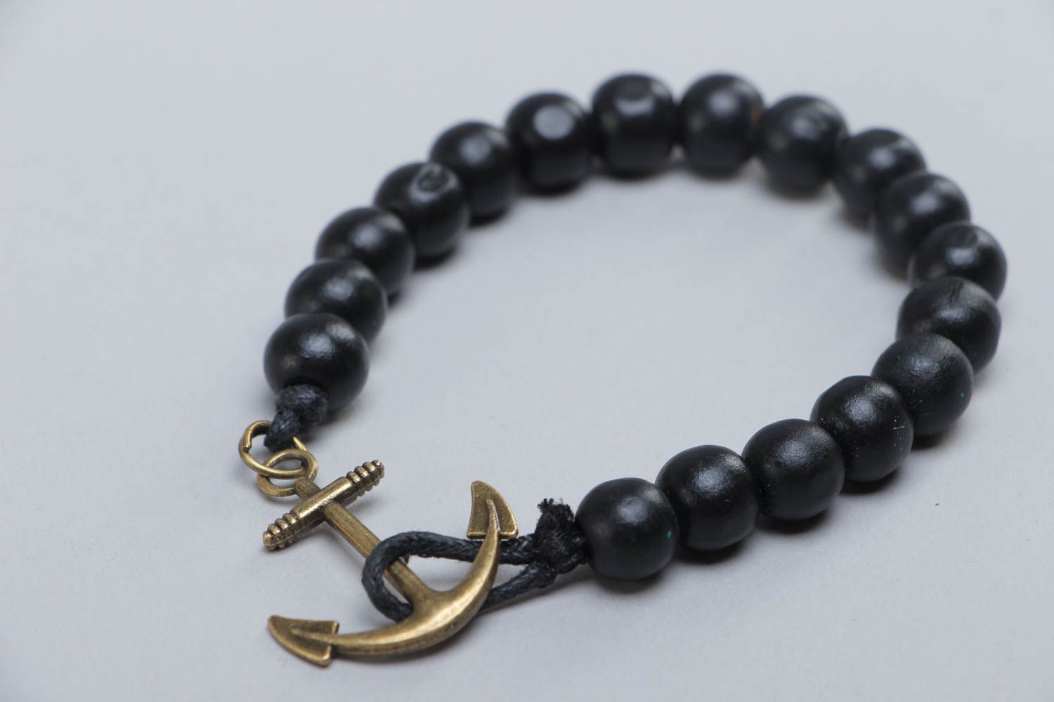 Handmade stylish black bracelet made of wooden beads with metal anchor photo 3