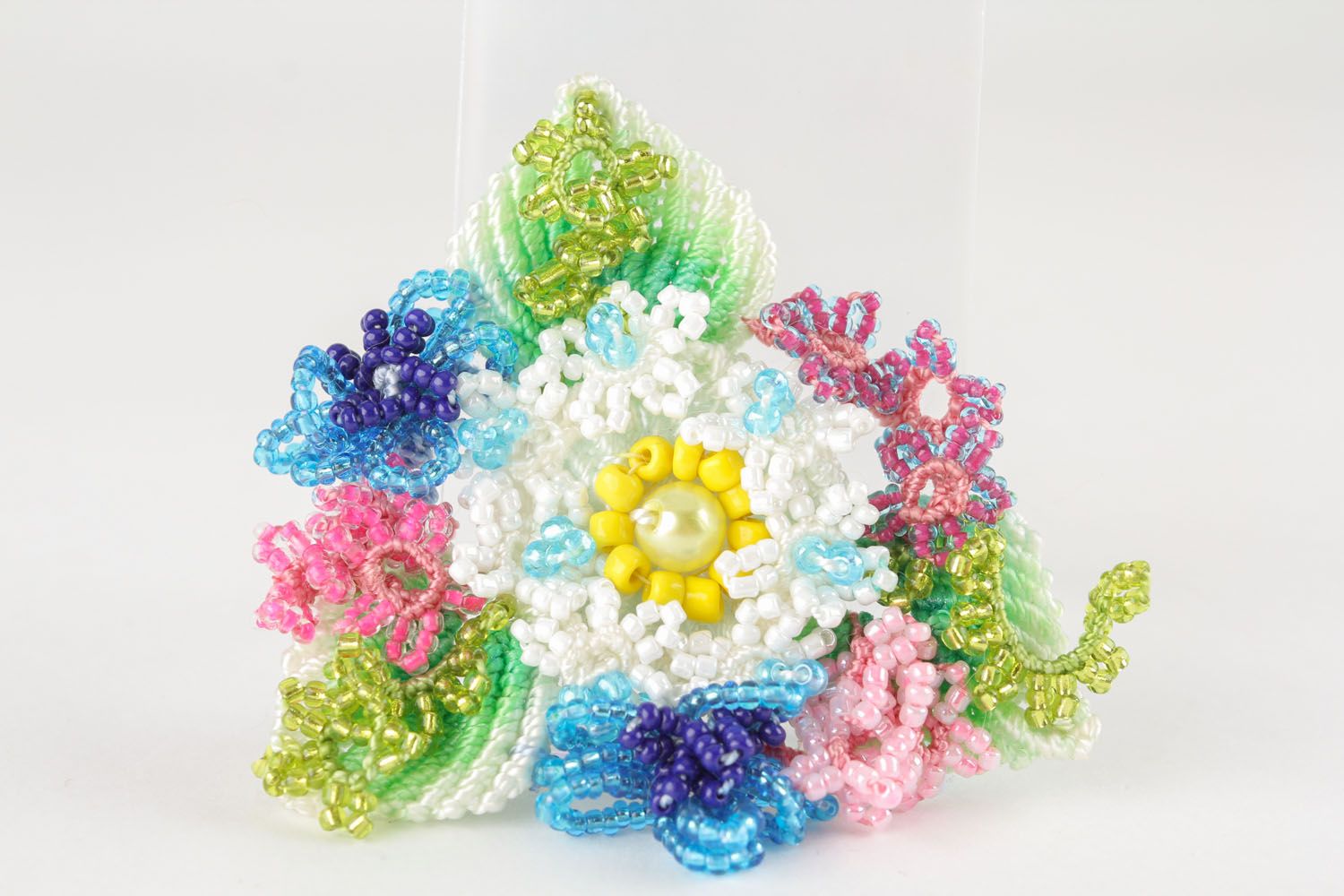 Broche artesanal têxtil em forma de uma flor colorida foto 2