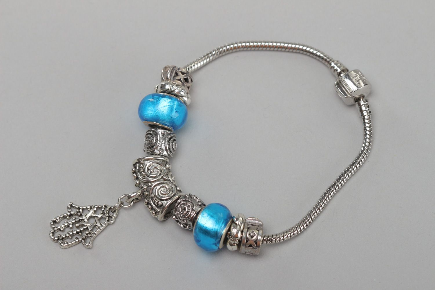 Thin handmade wrist bracelet with blue glass beads and metal charm for women photo 2