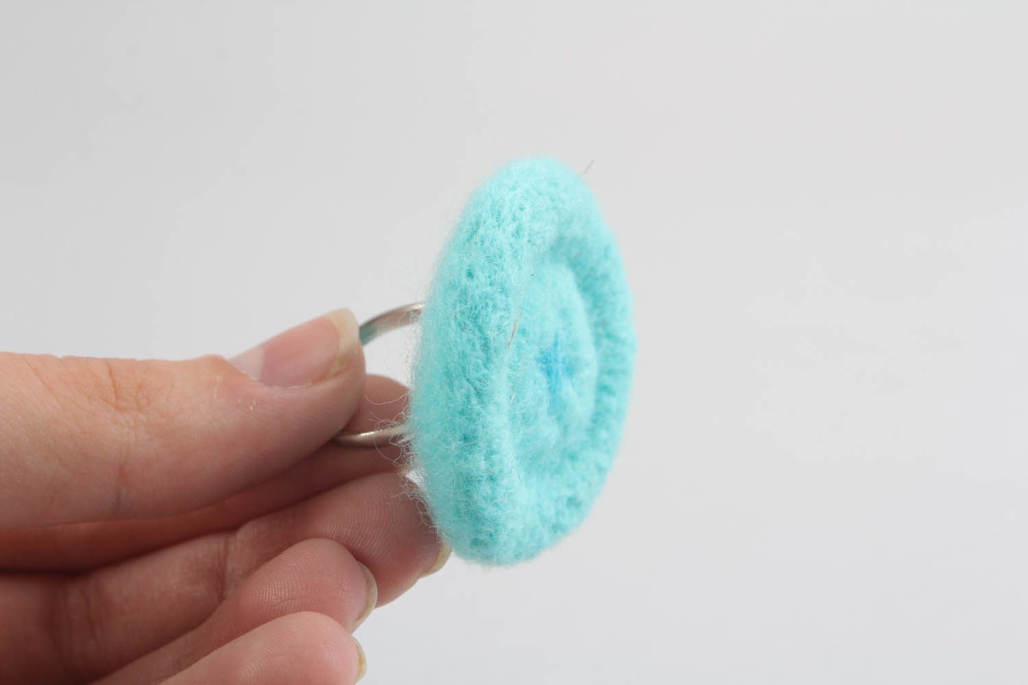 Anel artesanal feito de lã na técnica de feltragem seca na forma de um botão foto 2