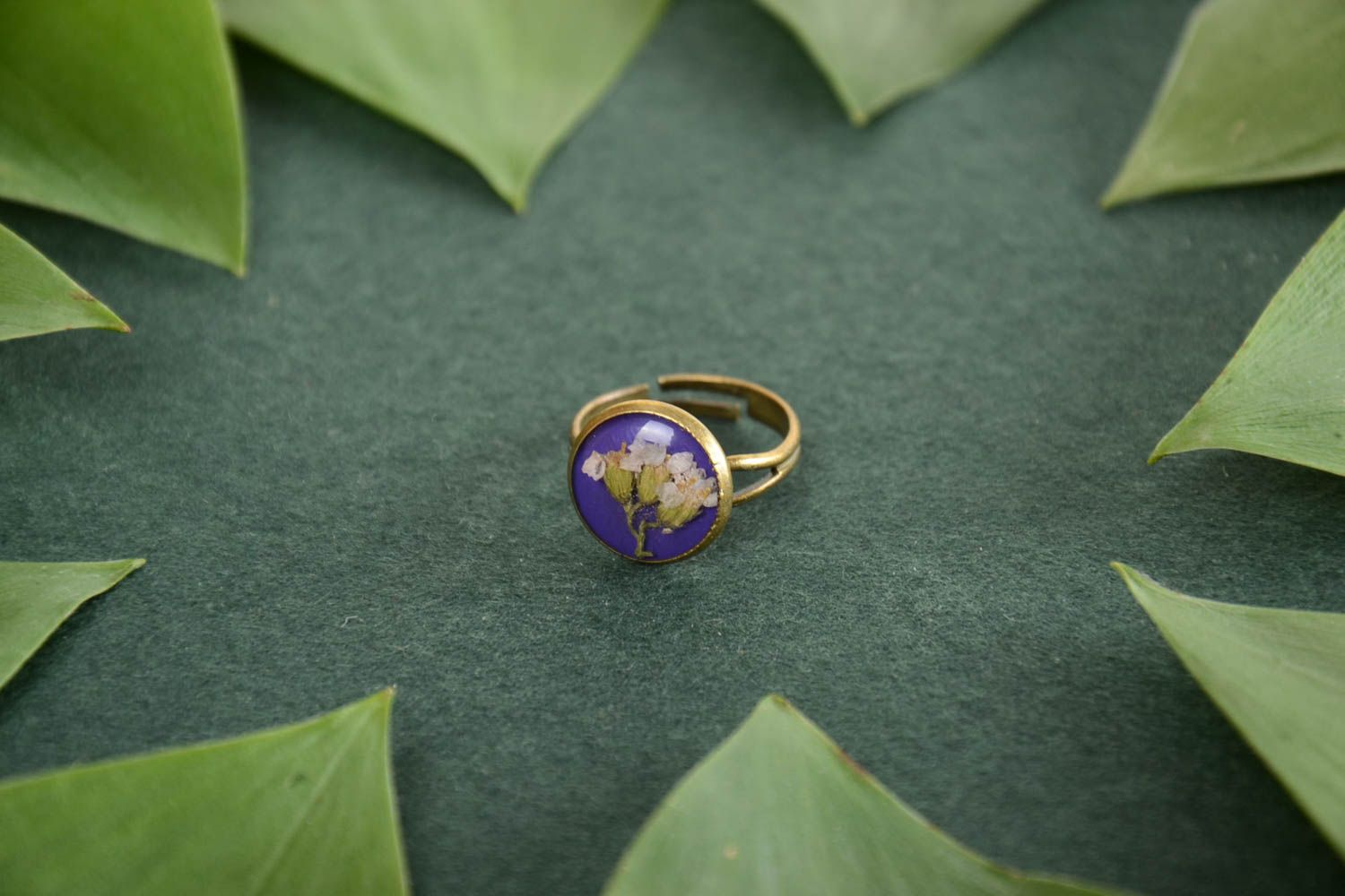 Small round handmade ring with dried flowers in epoxy resin on metal basis photo 1
