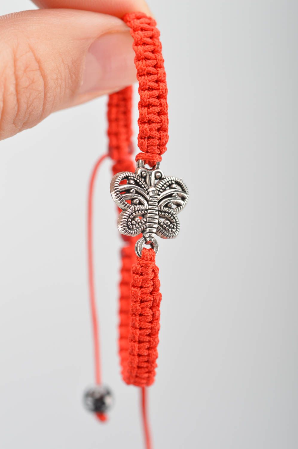 Bracelet tressé en fils de soie fin rouge avec papillon en métal fait main photo 3