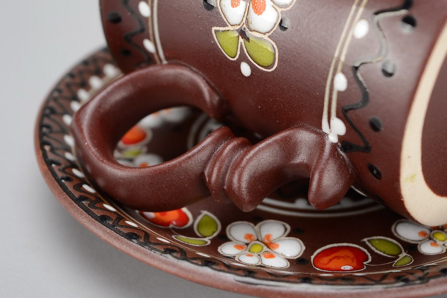 Ceramic glazed decorative brown te or coffee cup with handle, sauce and floral pattern photo 2