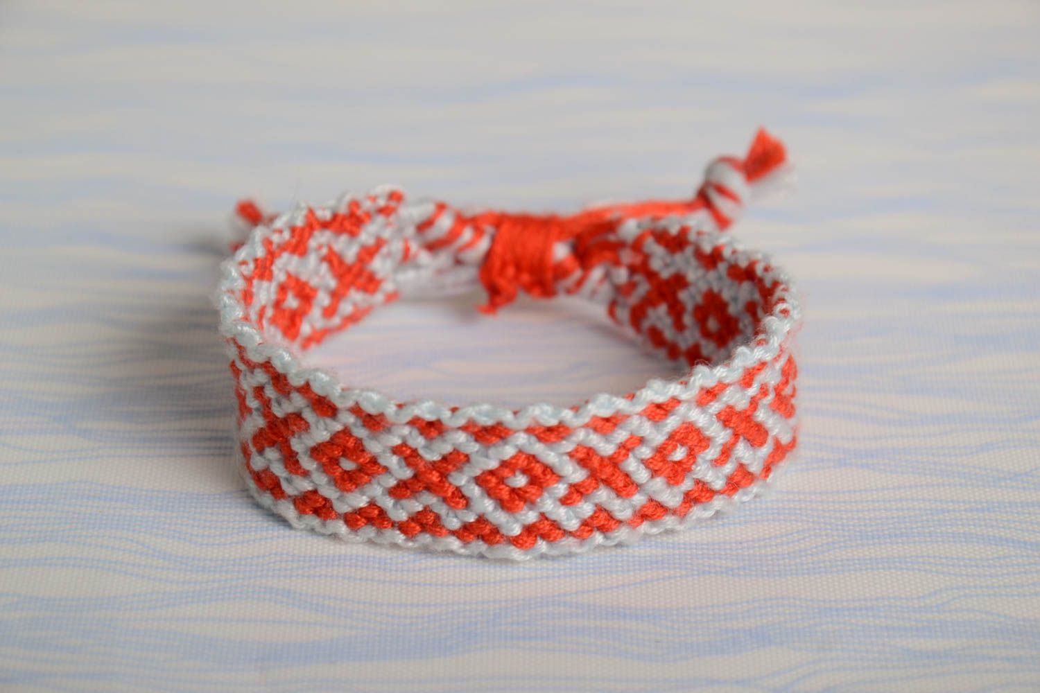 Тонкий яркий плетеный браслет из ниток мулине ручной работы красно-белый фото 1