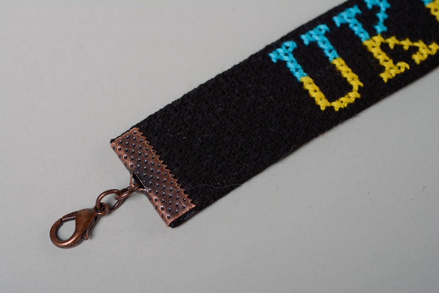 Handmade designer bracelet with embroidered lettering Ukraine on black background photo 3