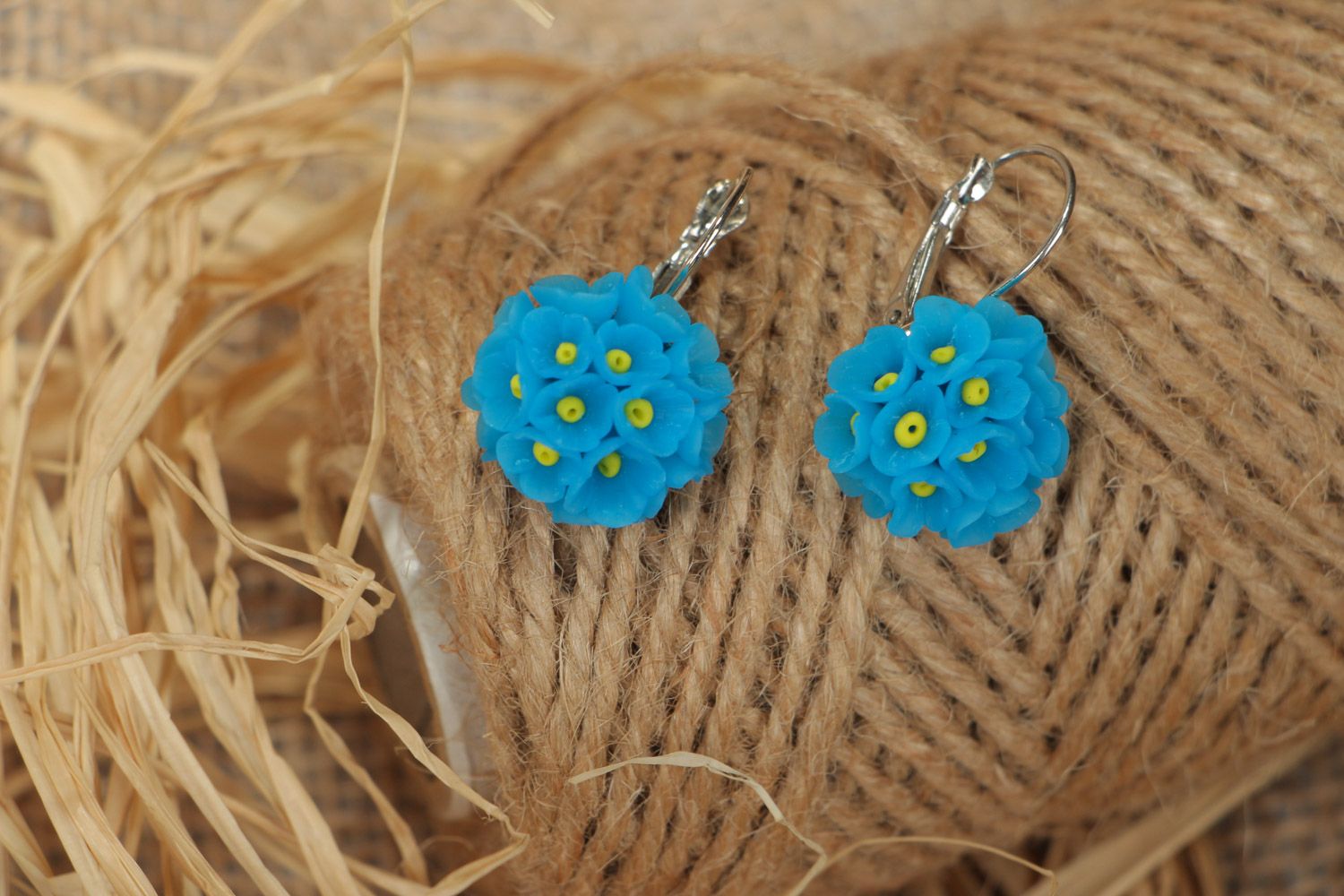 Small handmade polymer clay dangling earrings in the shape of blue flowers photo 1