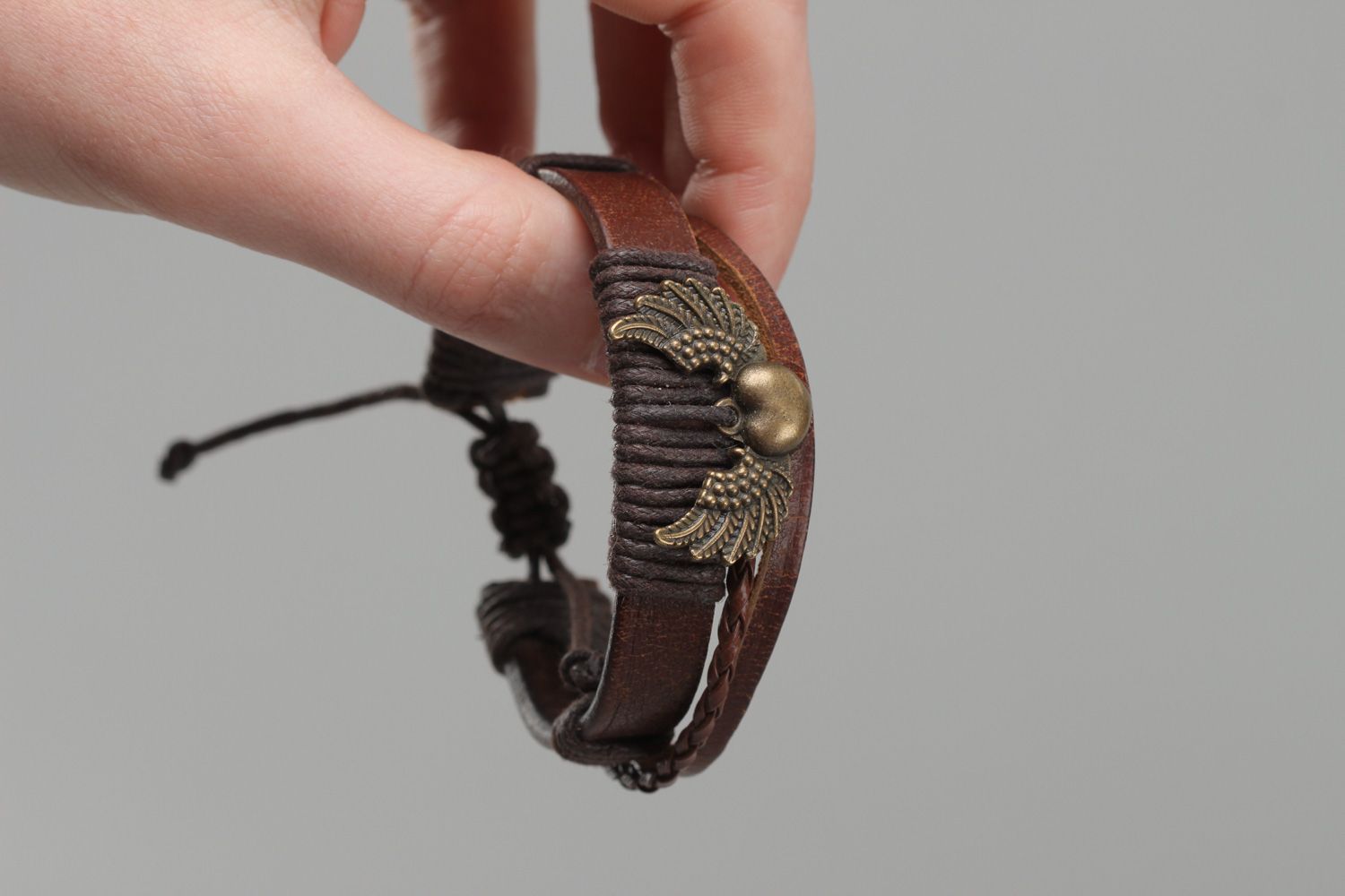 Dark brown handmade wrist bracelet woven of genuine leather with metal wings photo 5