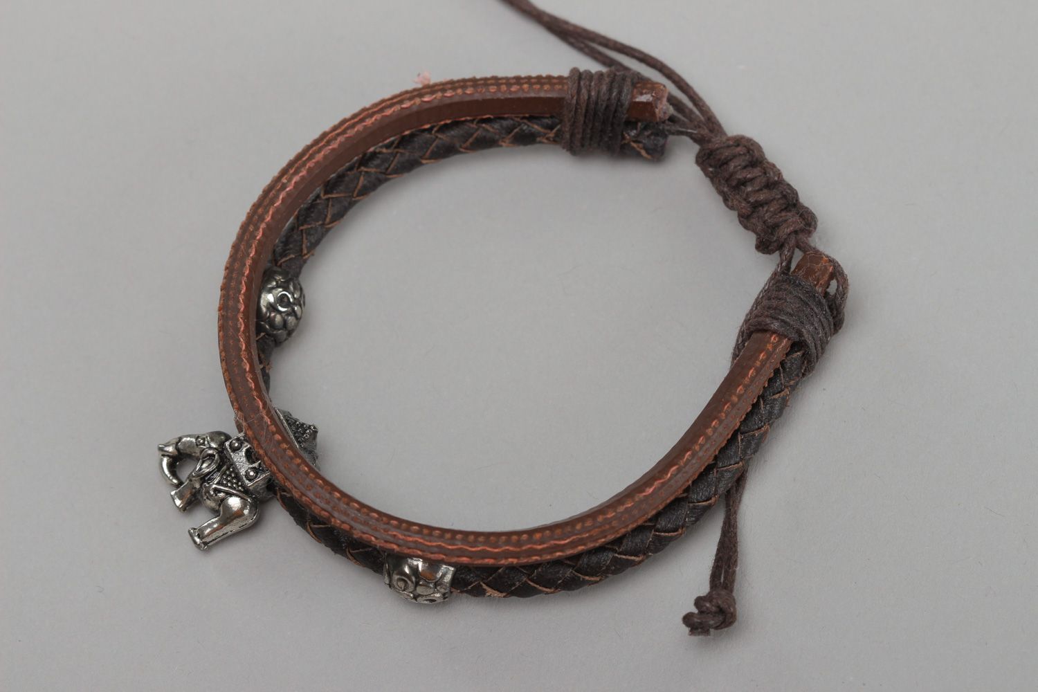 Handmade women's wrist bracelet woven of genuine leather of brown color photo 2