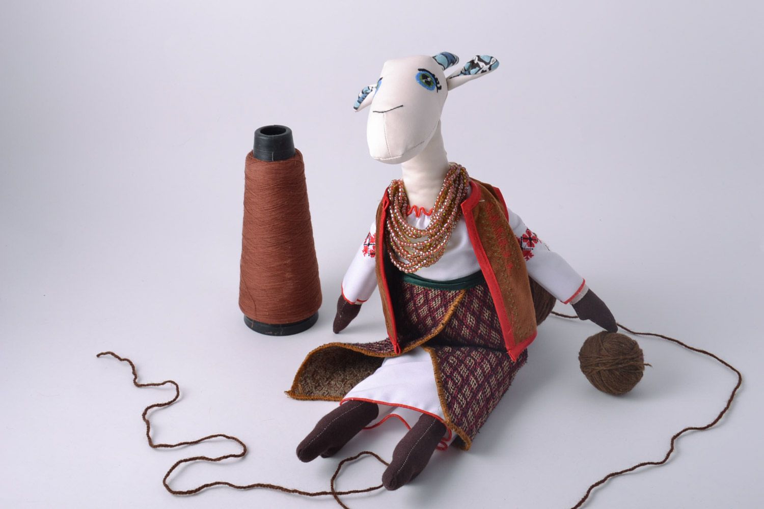 Handmade designer soft toy sewn of fabric tall goat in ethnic clothing photo 1