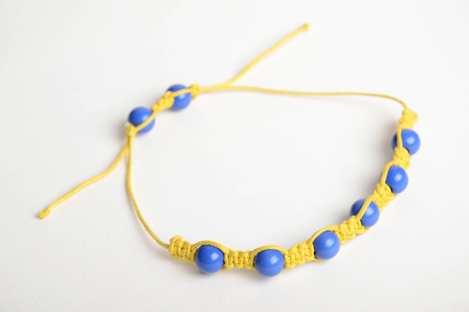 Handmade friendship bracelet woven of yellow cord and blue beads for children photo 3