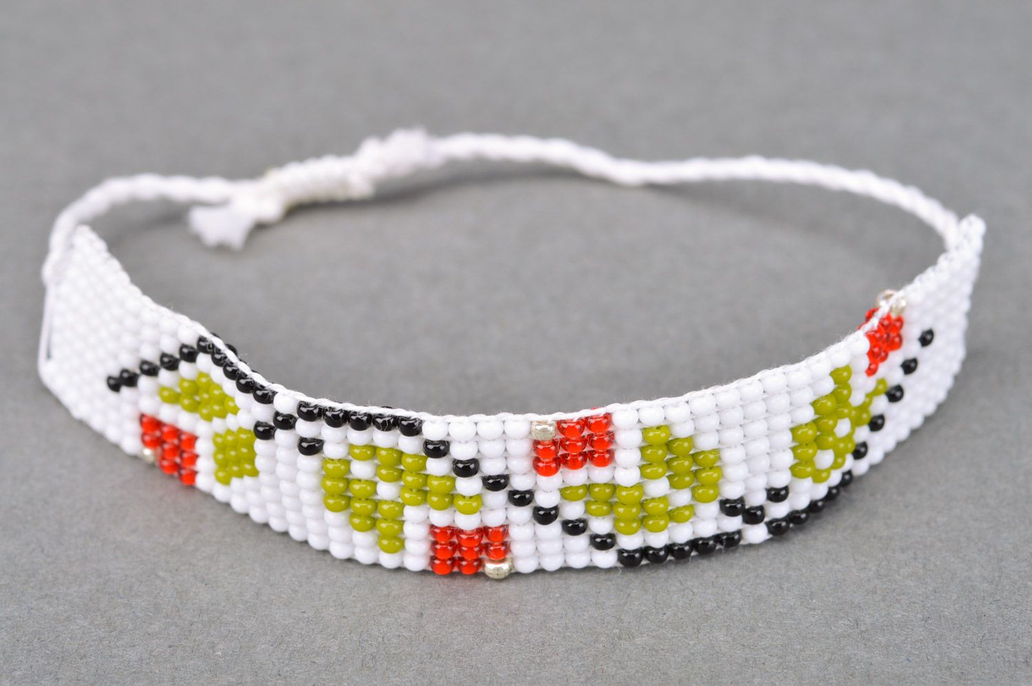 Beautiful women's handmade wrist bracelet woven of threads and beads of light color photo 2