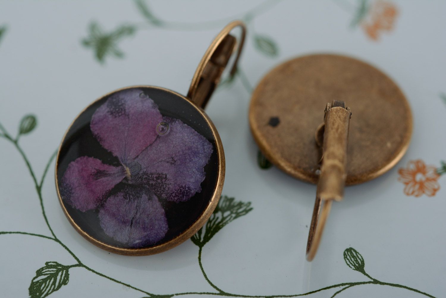Homemade round black dangle earrings with violet flowers in epoxy resin photo 4