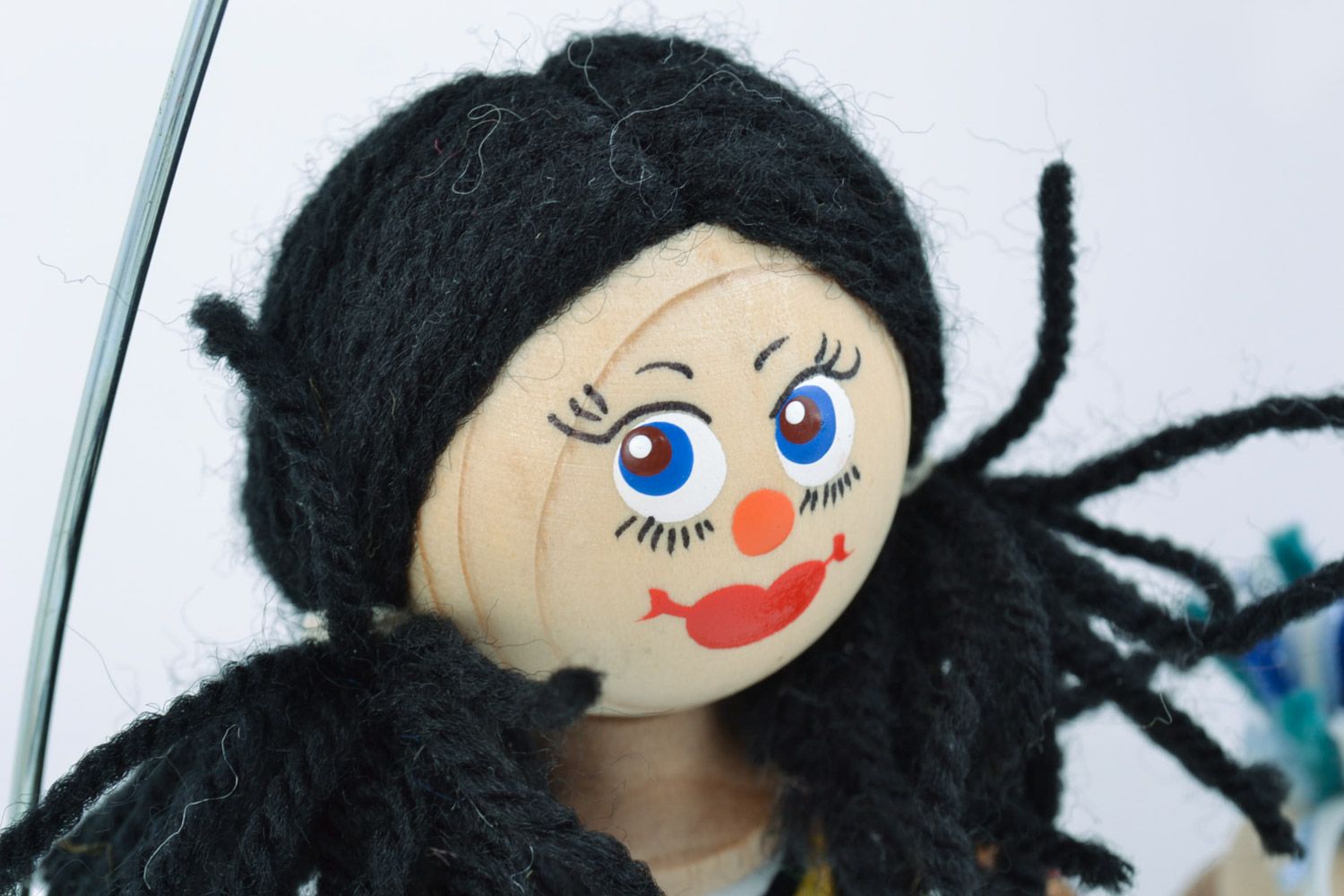 Bright painted homemade wooden eco toy doll with black hair on bench for kids photo 4