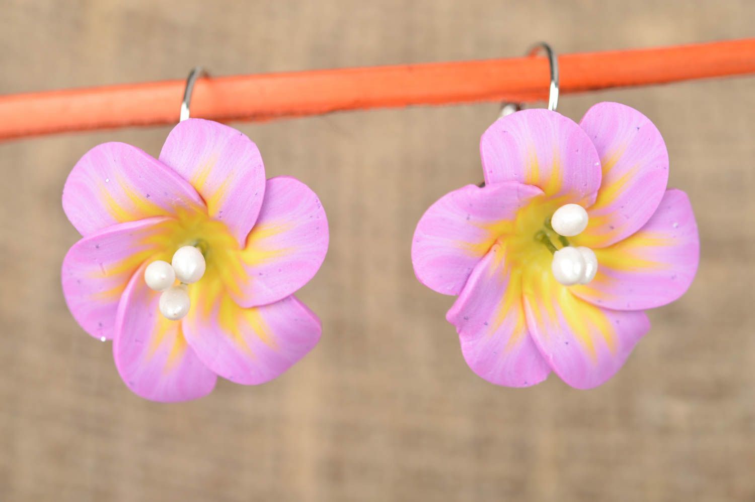 Feine helle violette originelle handgemachte Ohrringe aus Polymerton mit Blumen foto 1