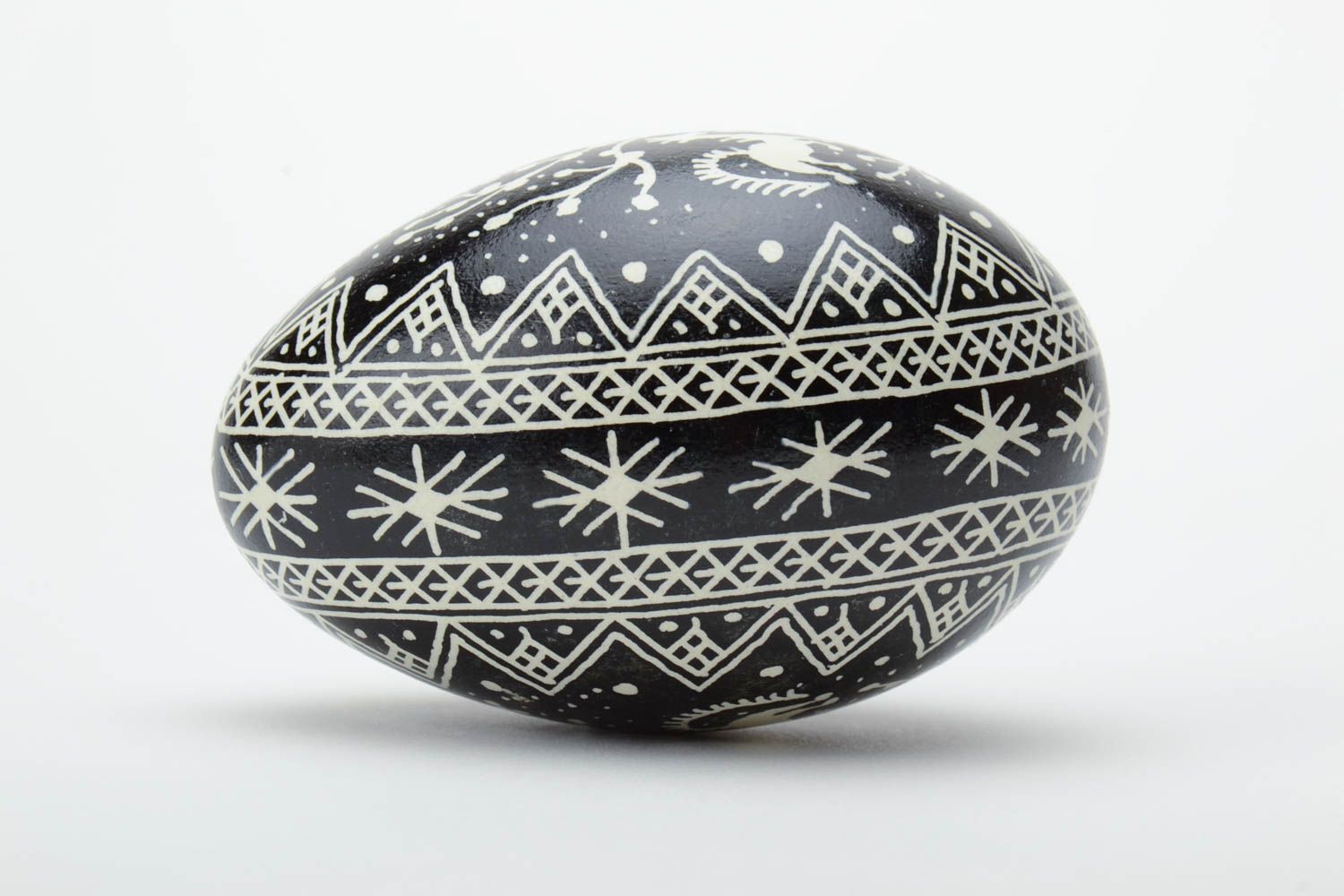 Huevo de ganso de Pascua artesanal blanquinegro con imágenes de caballos y pintura con cera foto 3