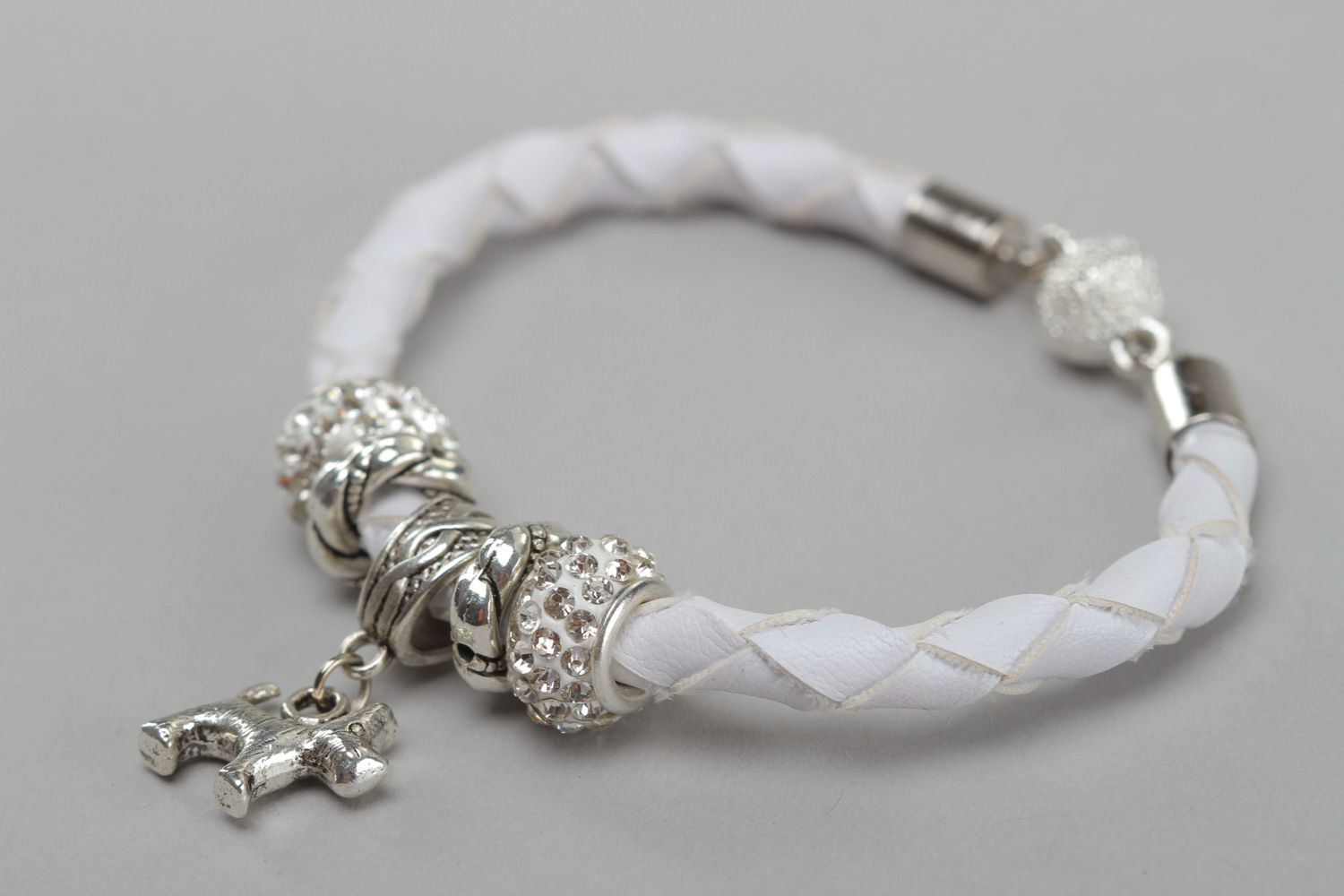 Handmade wrist bracelet woven of white faux leather with metal dog charm photo 2