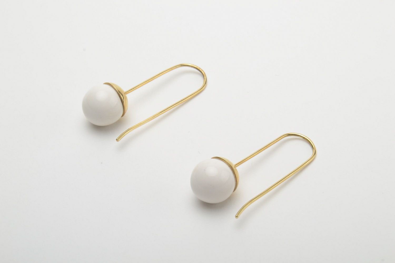 Stylish white handmade ceramic ball earrings with brass frame photo 2