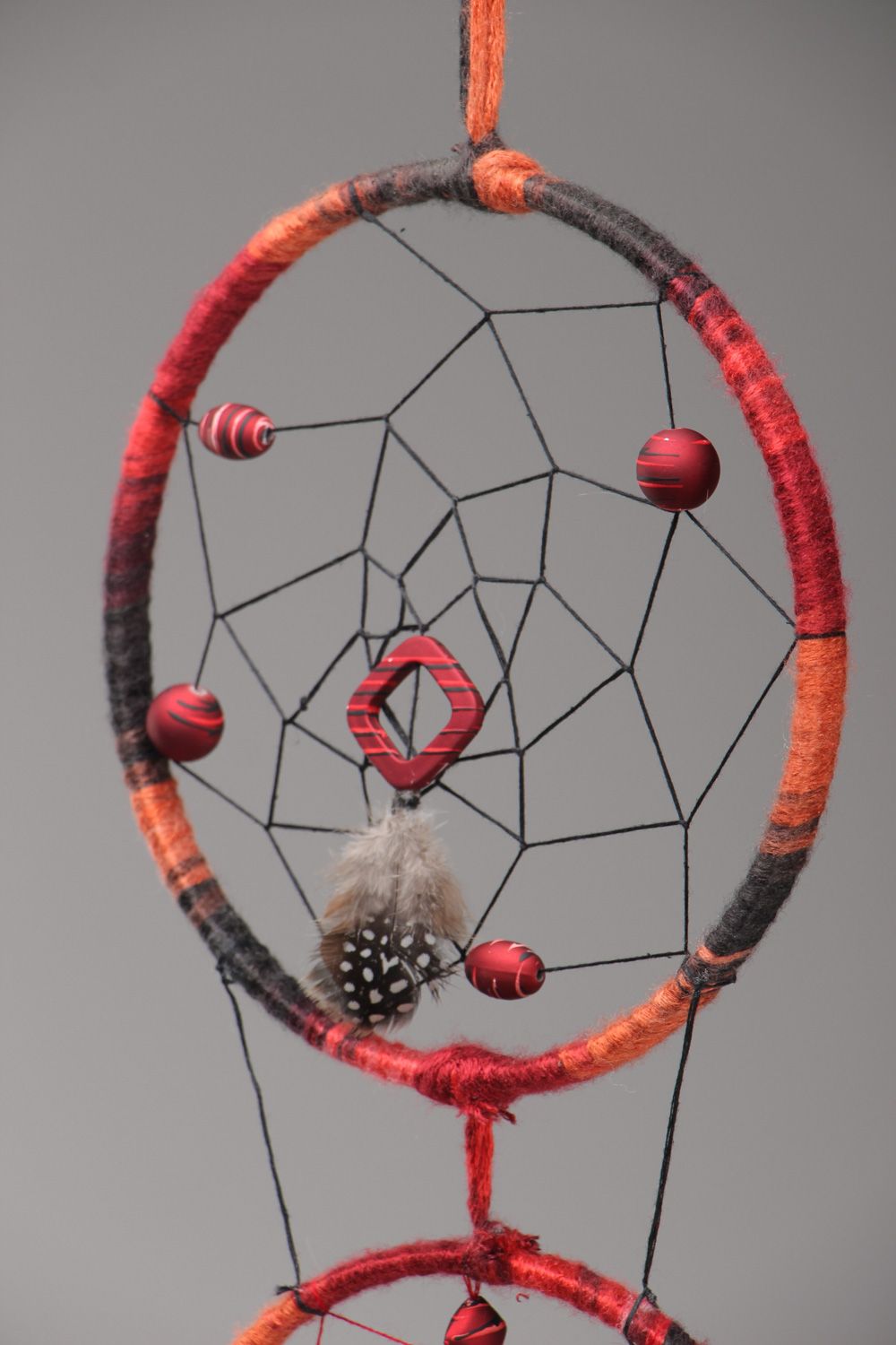Long red homemade dreamcatcher wall hanging with natural stones and feathers photo 3