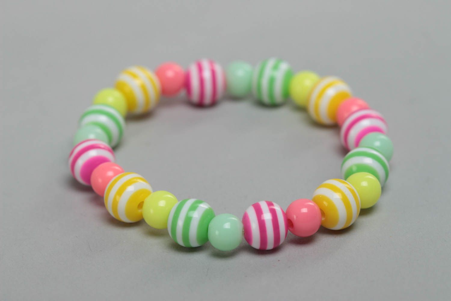 Браслет из пластиковых бусин ручной работы для девочки разноцветный полосатый фото 3