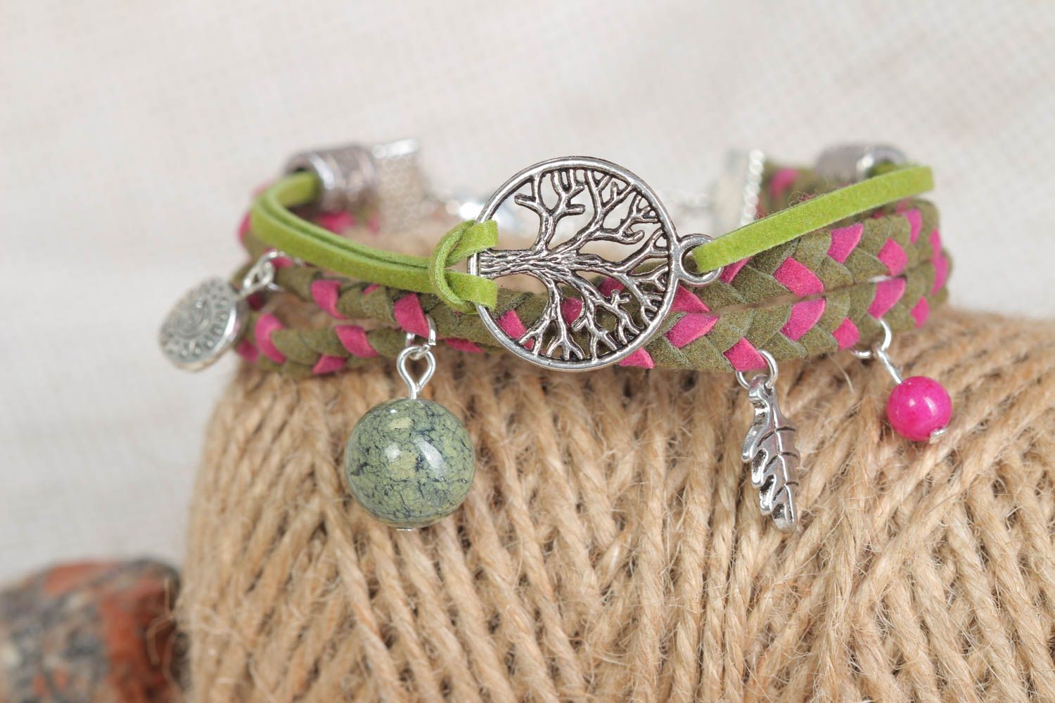 Bracelet en cuir tressé fin vert-rose avec breloques métalliques fait main photo 1