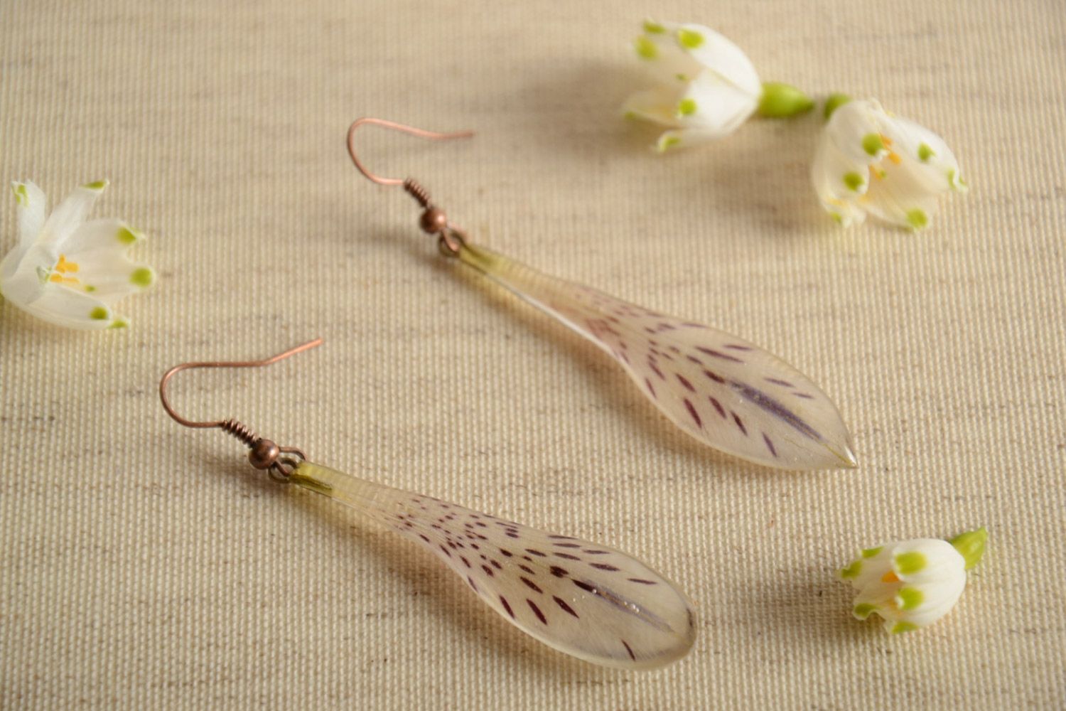 Handmade tender drop-shaped dangling earrings with natural flowers in epoxy resin photo 1