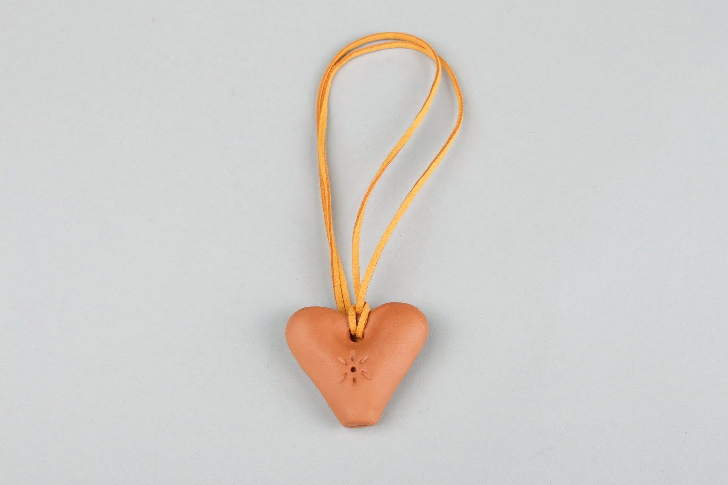 Un colgante silbato en la forma del corazón, un instrumento musical y un juguete para los niños. foto 5
