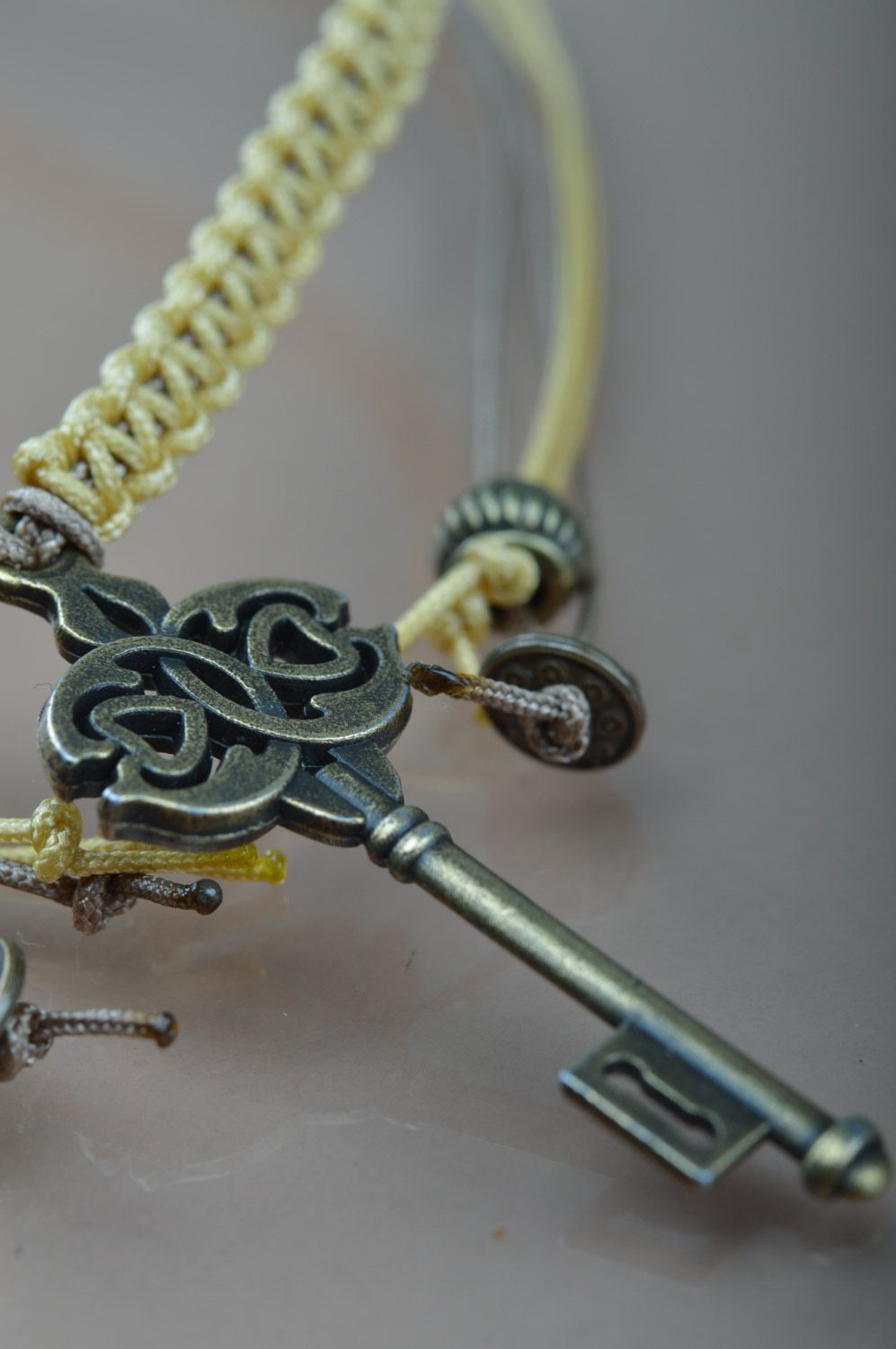Handmade friendship wrist bracelet woven of cord with metal key-shaped charm photo 4