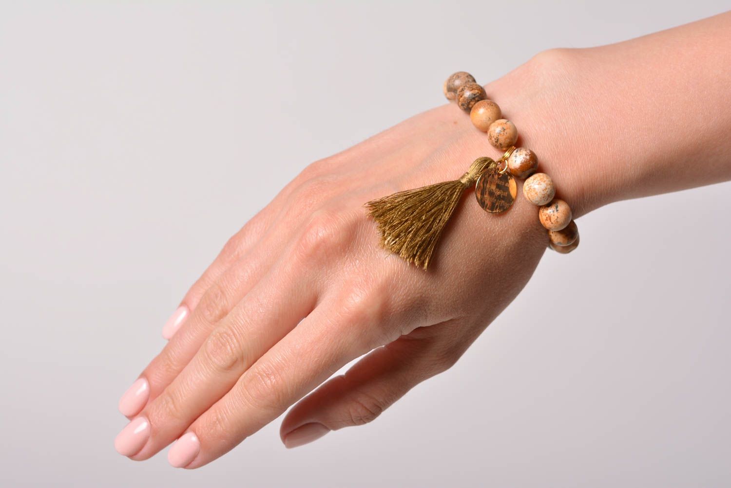 Handmade jasper bead wrist bracelet in beige color palette with charm and tassel photo 1