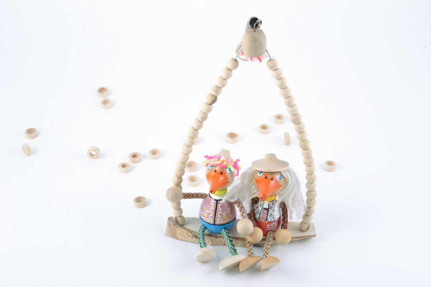 Handmade painted wooden eco toys in the shape of 2 funny ducks sitting on swing photo 1