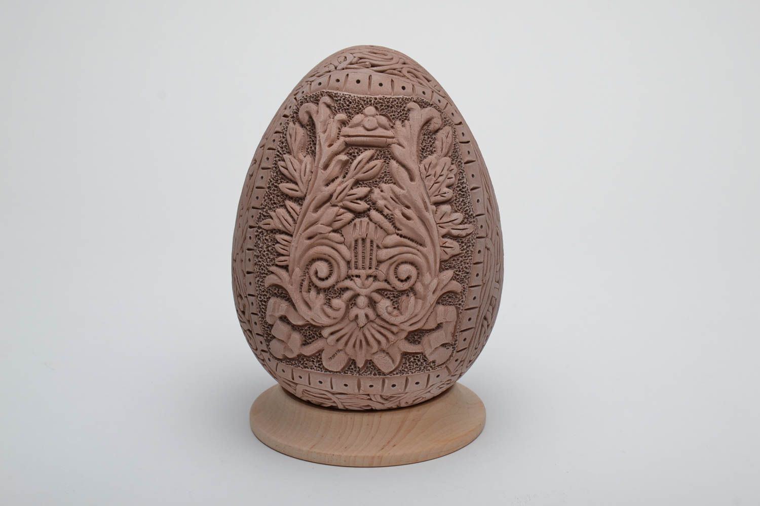 Ceramic Easter egg with elegant molded elements and wooden holder photo 2