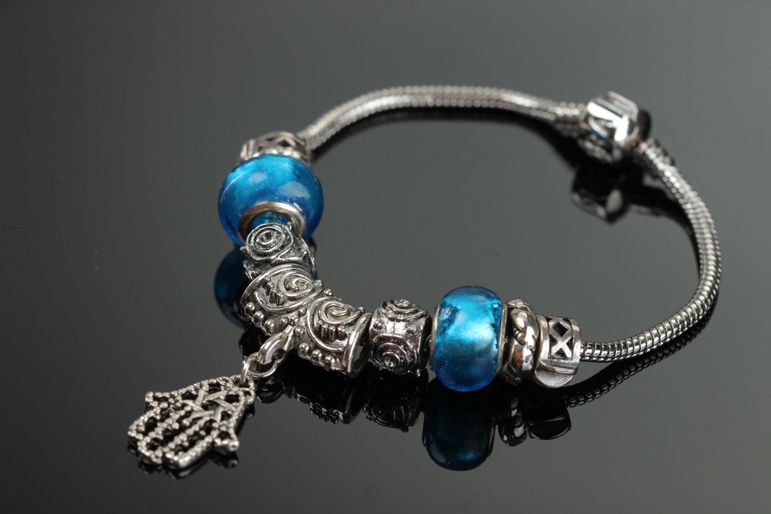 Thin handmade wrist bracelet with blue glass beads and metal charm for women photo 1