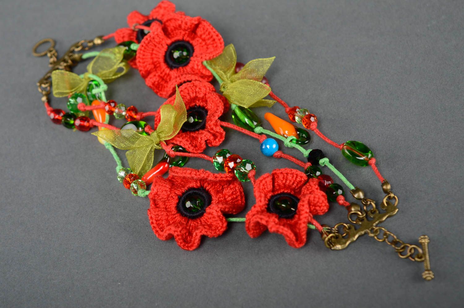 Red bracelet with crochet flowers photo 1