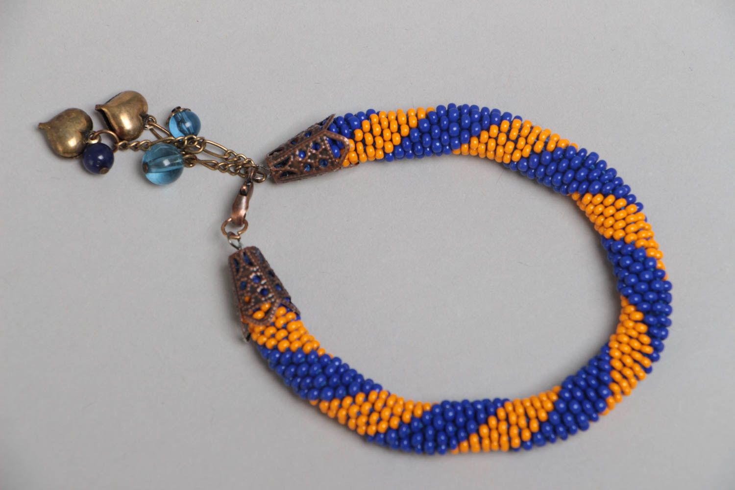 Handmade designer striped blue and yellow beaded cord wrist bracelet with charms photo 2