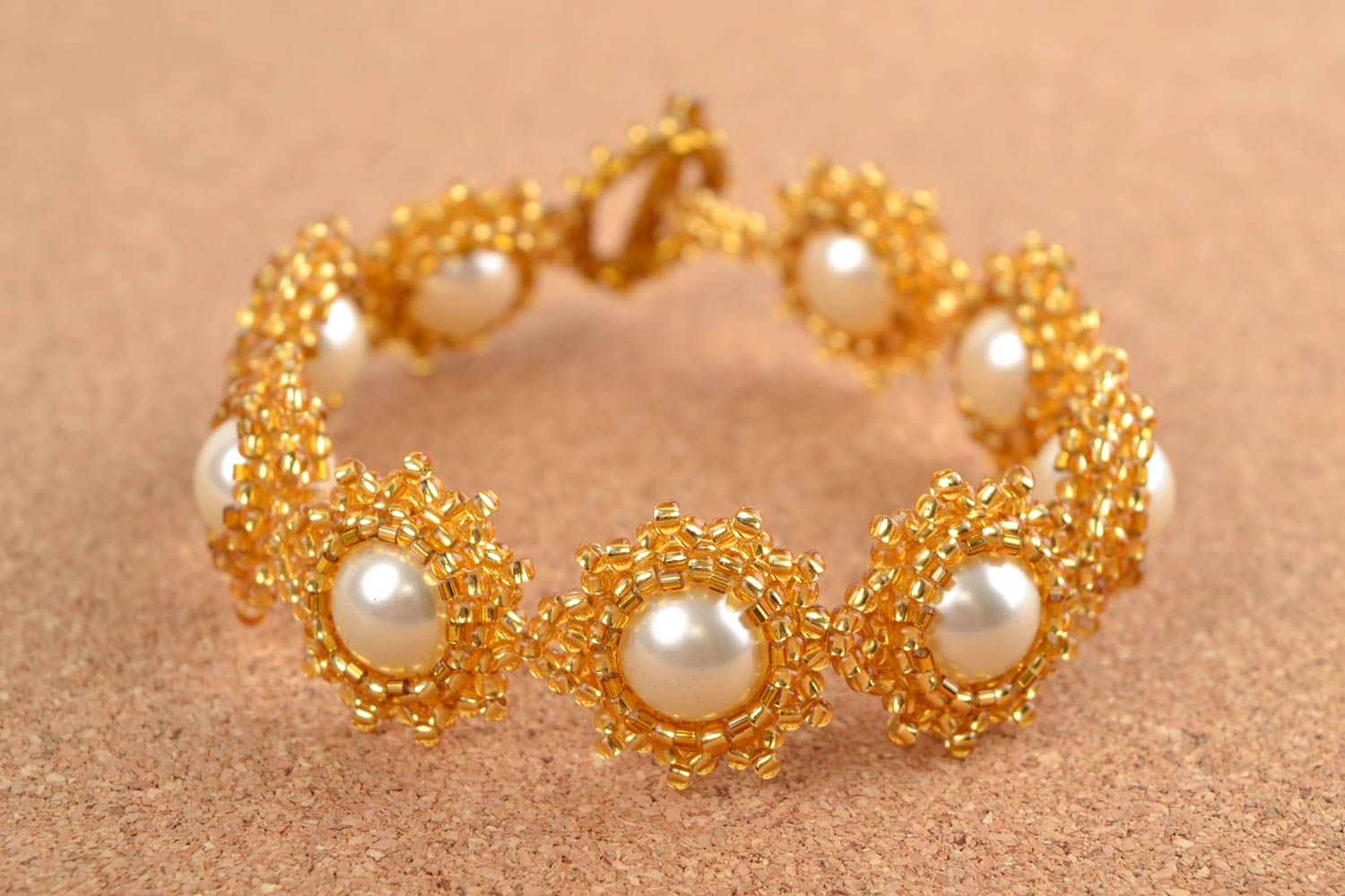 Beaded bracelet in the shape of flowers in gold and white colors photo 1