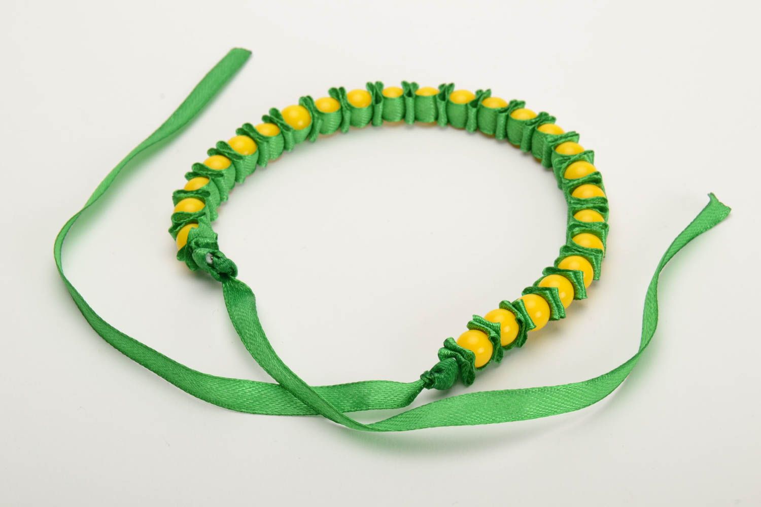 Pulsera artesanal de cinta de raso y cunetas plásticas verde y amarilla foto 3