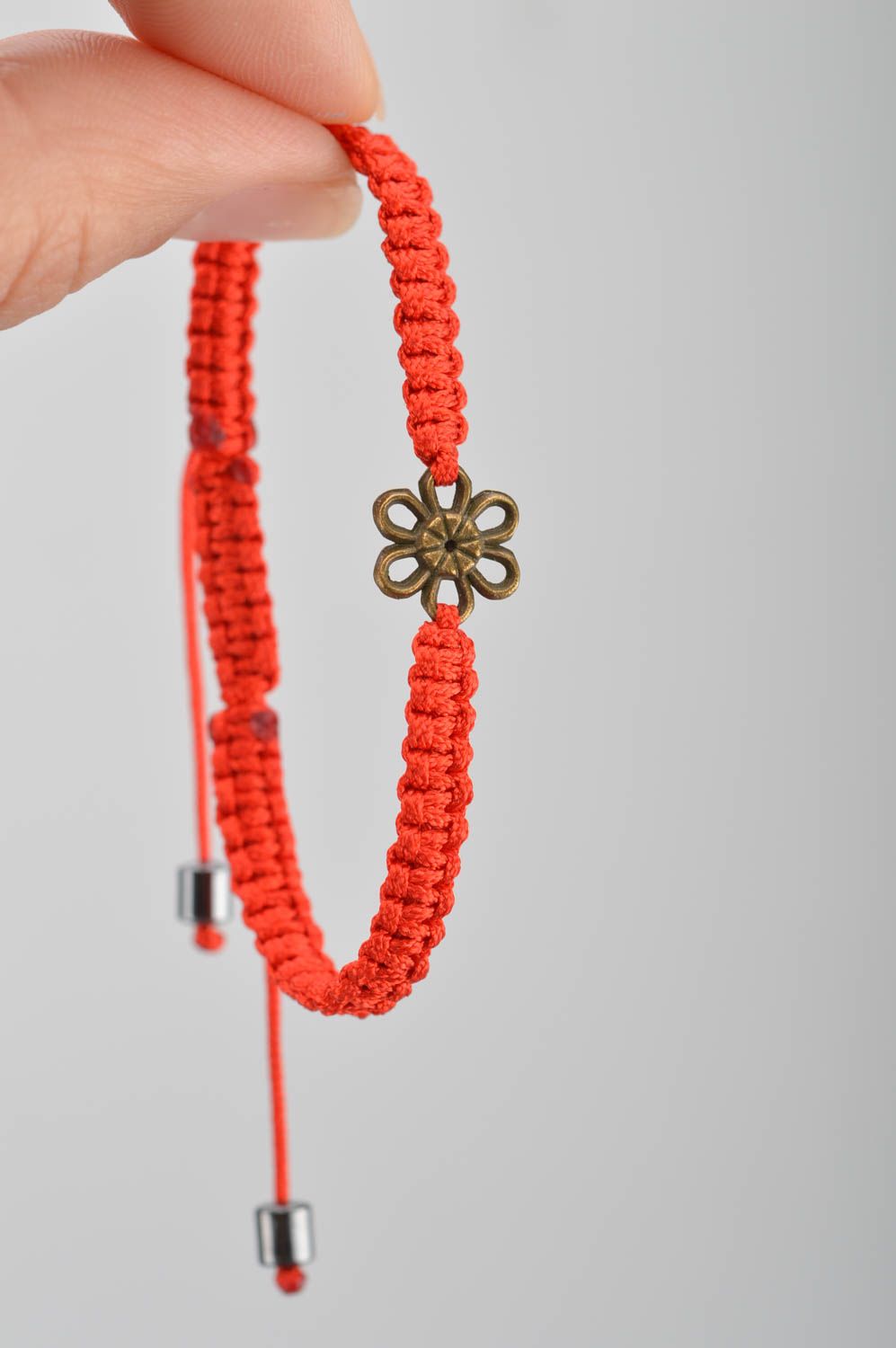 Frauenhaftes schönes handgemachtes Armband aus Fäden mit Einsatz aus Metall rot foto 3