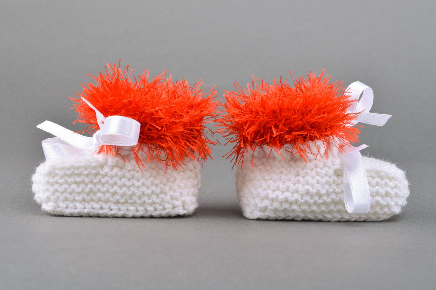Beautiful handmade knitted baby booties of white color with red edge and satin bow photo 2