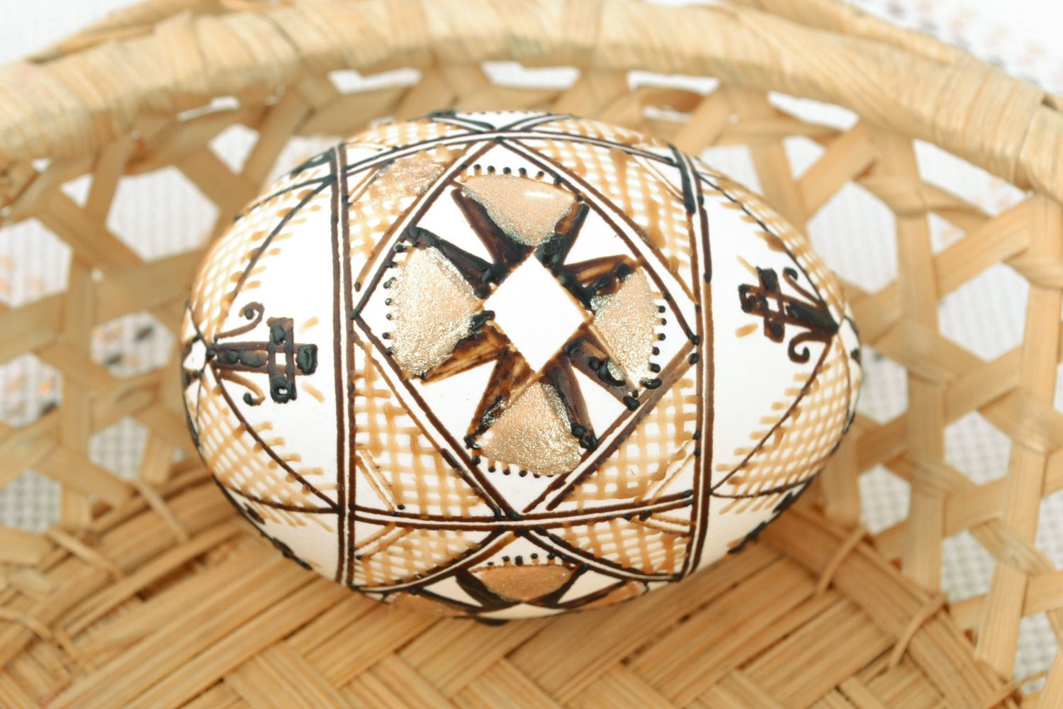 White decorative Easter egg with handmade wax painting in light color palette photo 1