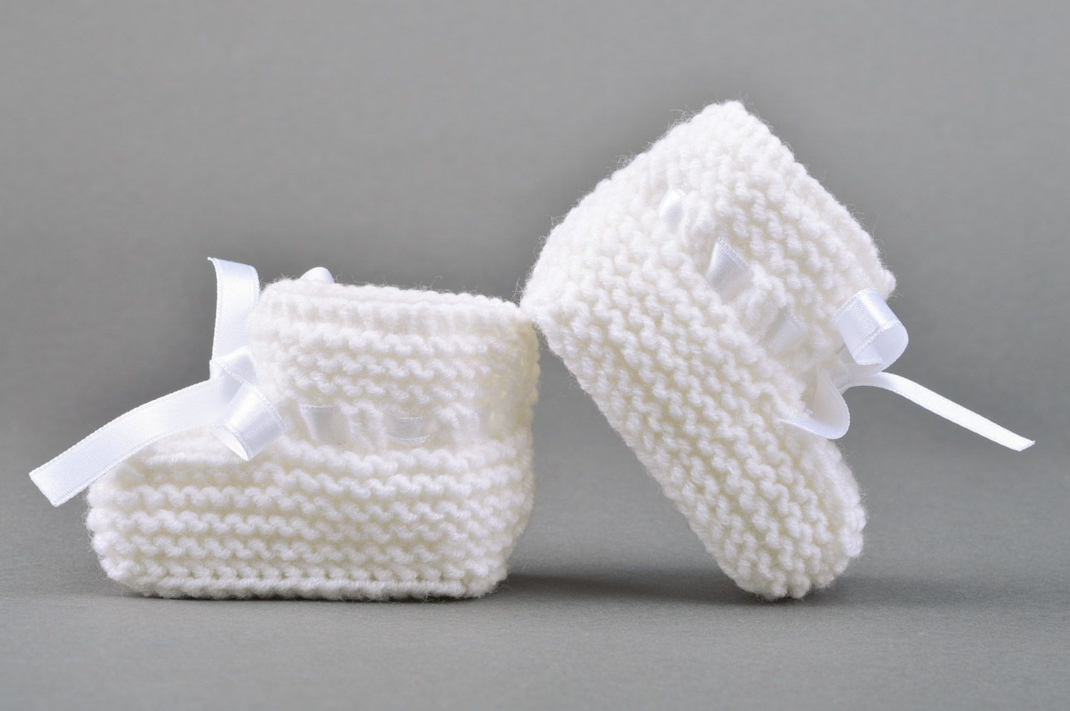 Handmade small knitted baby booties of white color with satin bow for girls photo 5